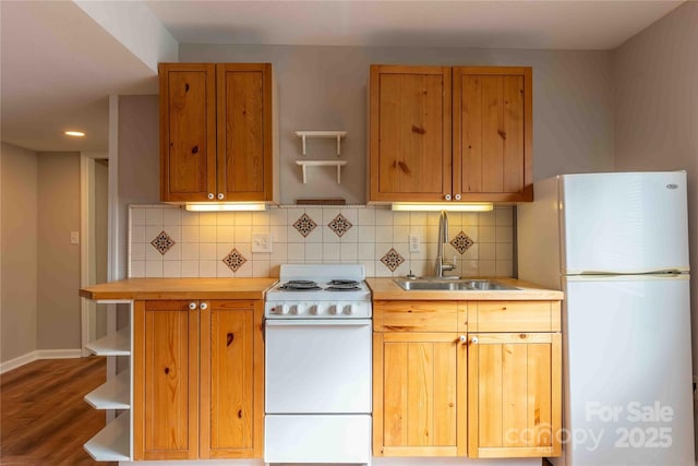 kitchen featuring white appliances, sink, hardwood / wood-style floors, and backsplash