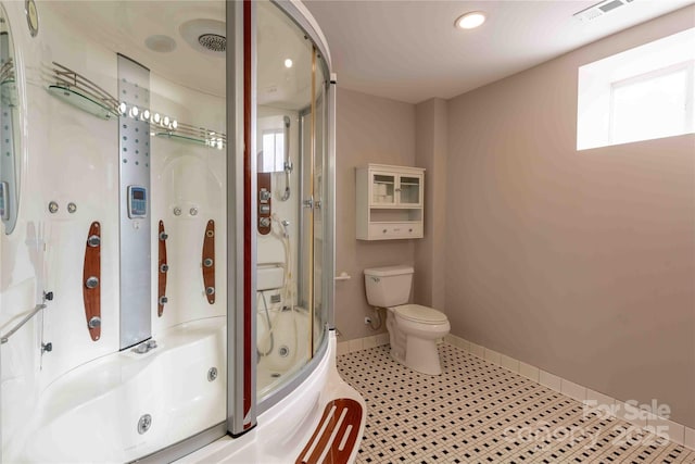 bathroom with shower / bath combination with glass door, tile patterned floors, and toilet