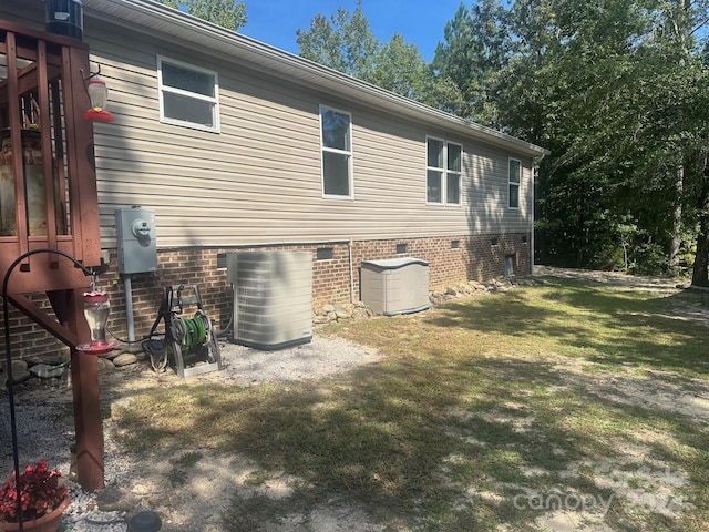 view of home's exterior featuring central AC and a yard