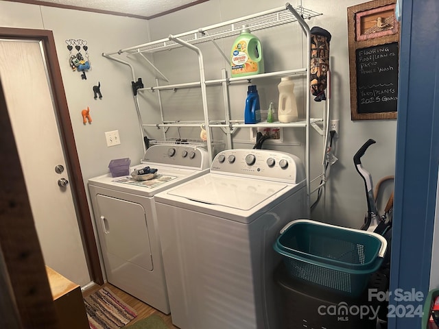 laundry area with ornamental molding, separate washer and dryer, hardwood / wood-style floors, and a textured ceiling