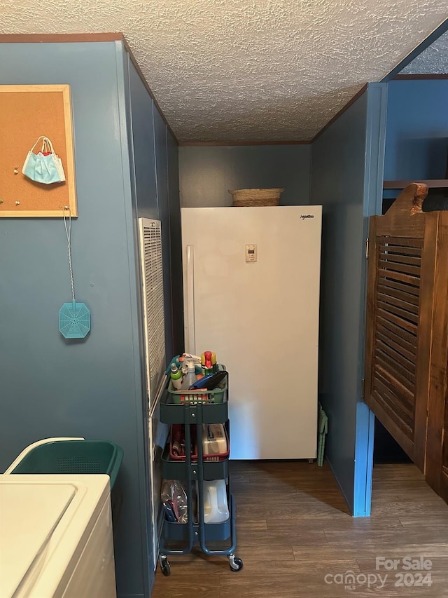 laundry area featuring a textured ceiling and dark hardwood / wood-style floors