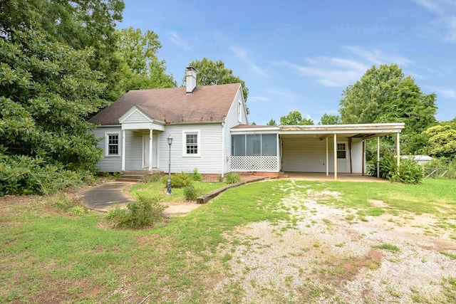 rear view of house featuring a yard and a carport