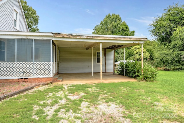 rear view of house with a carport and a yard