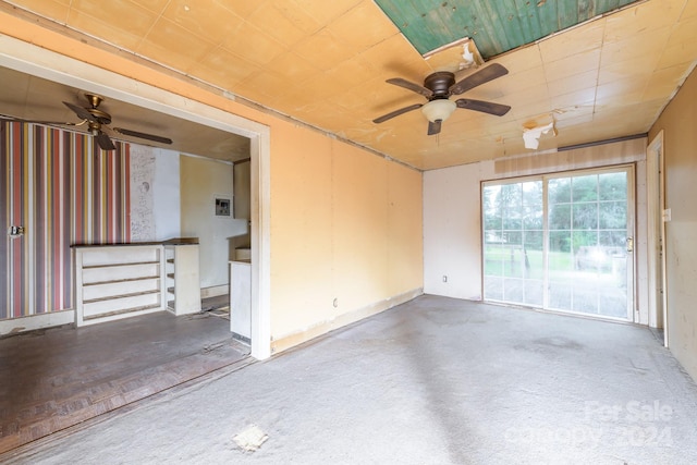 unfurnished room with ceiling fan and concrete flooring