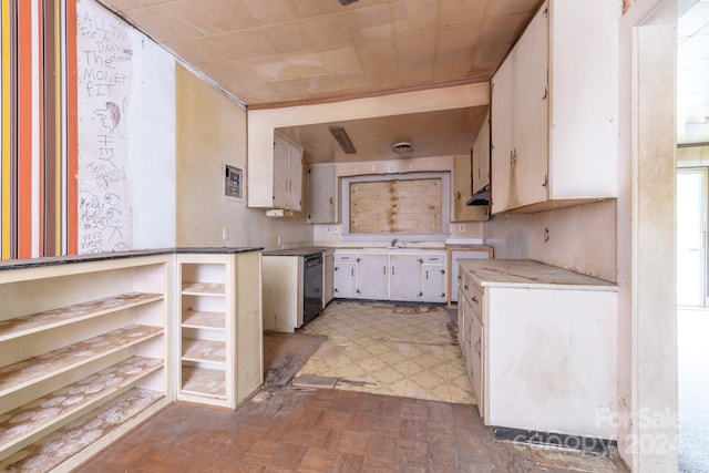 kitchen featuring black dishwasher, sink, parquet flooring, and white cabinets