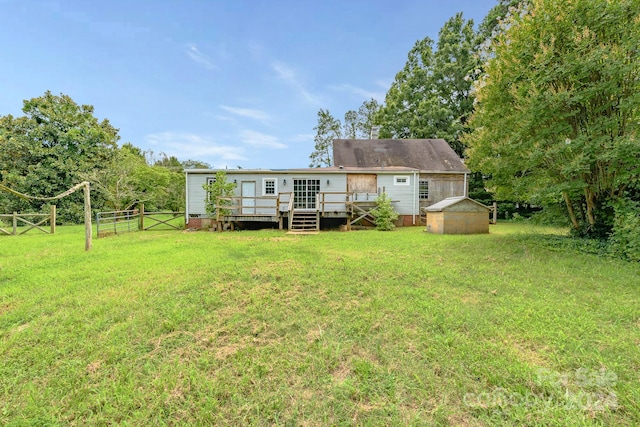 back of house featuring a wooden deck, an outdoor structure, and a yard