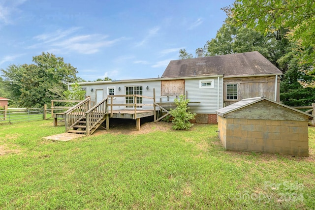 rear view of house featuring a deck and a yard