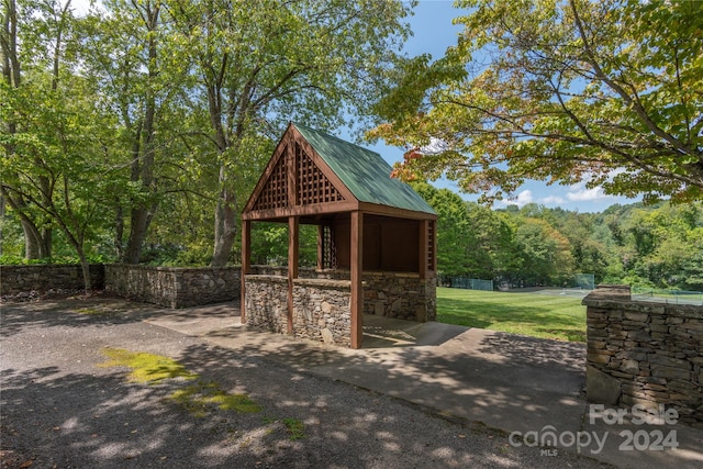 view of property's community featuring an outdoor structure and a lawn