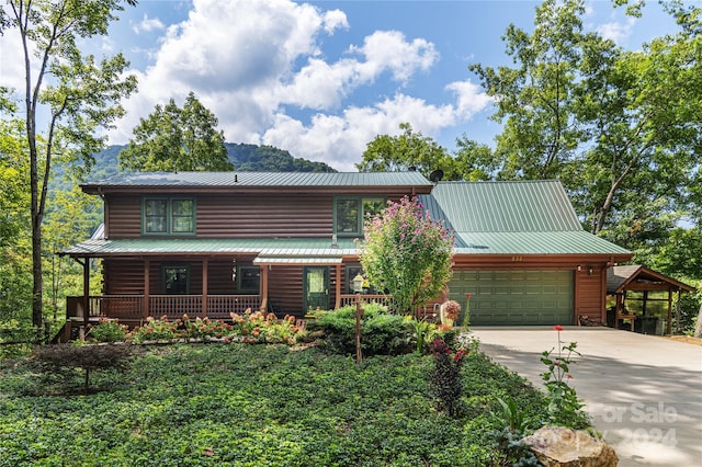 log home featuring covered porch, a garage, and a carport