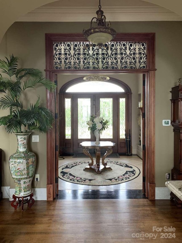 foyer featuring crown molding and wood-type flooring