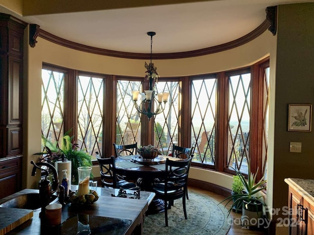 dining space with crown molding and an inviting chandelier