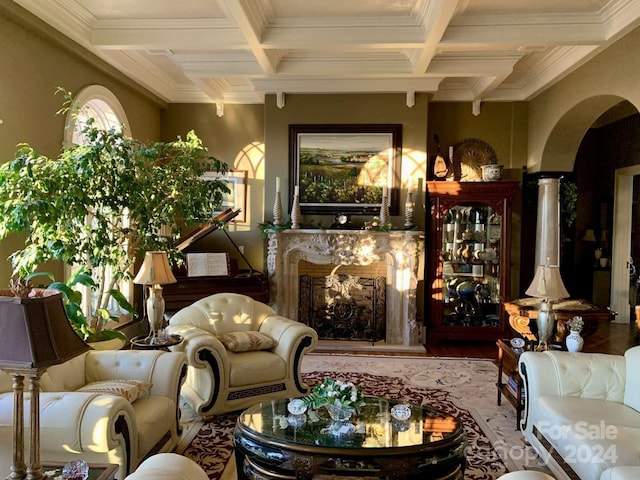 living room with hardwood / wood-style floors, coffered ceiling, a premium fireplace, and ornamental molding