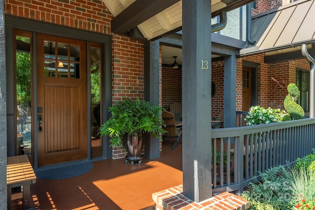 doorway to property with a standing seam roof, brick siding, and metal roof