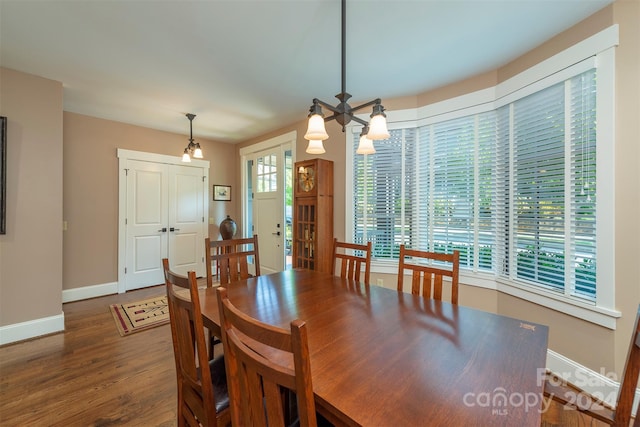 dining area with wood finished floors, baseboards, and a chandelier