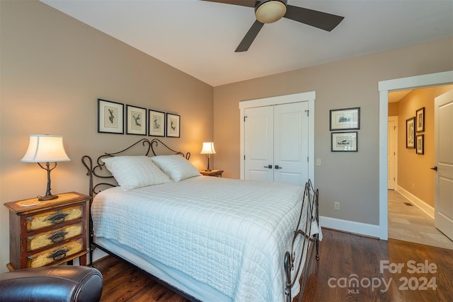 bedroom featuring a closet, a ceiling fan, baseboards, and dark wood-style flooring