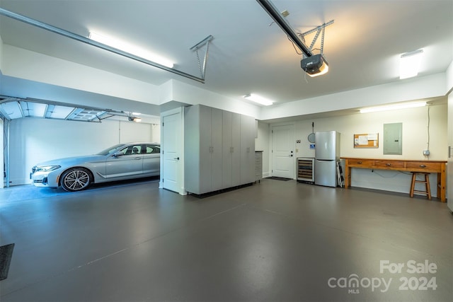 garage featuring electric panel, wine cooler, a garage door opener, and freestanding refrigerator