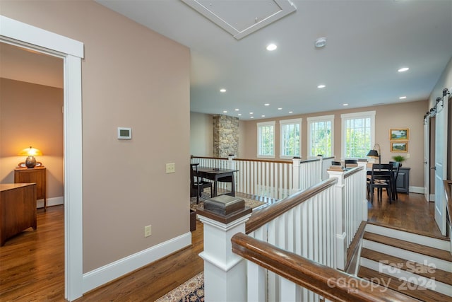corridor featuring baseboards, attic access, an upstairs landing, recessed lighting, and wood finished floors