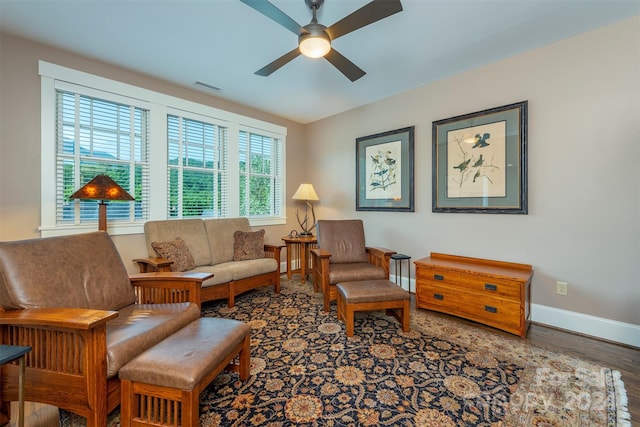 sitting room with wood finished floors, a ceiling fan, visible vents, and baseboards
