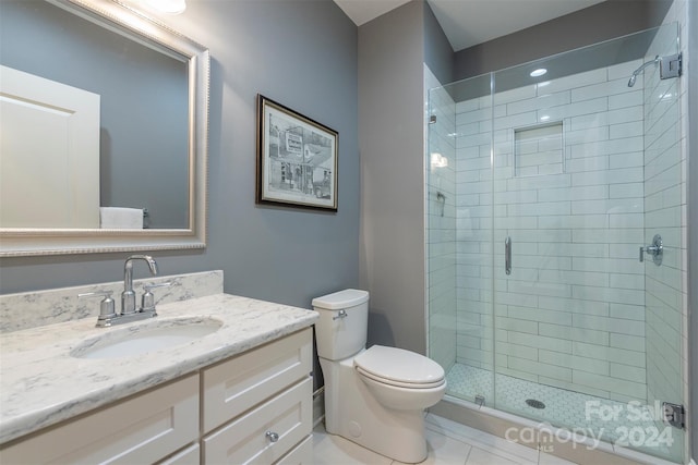 bathroom featuring vanity, a shower stall, and toilet