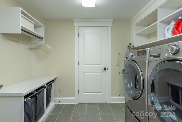 clothes washing area featuring baseboards, laundry area, and washing machine and clothes dryer