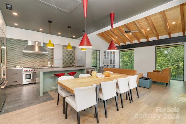 dining space featuring wood ceiling, ceiling fan, vaulted ceiling with beams, and light hardwood / wood-style floors