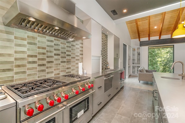 kitchen with wood ceiling, double oven range, sink, vaulted ceiling with beams, and wall chimney exhaust hood