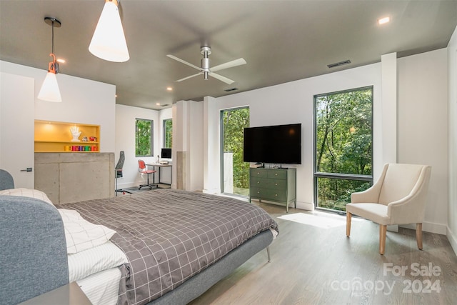 bedroom featuring multiple windows, ceiling fan, and light hardwood / wood-style floors