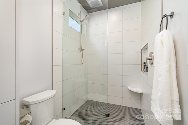 bathroom featuring toilet and a tile shower