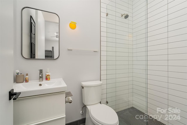 bathroom featuring tiled shower, vanity, and toilet