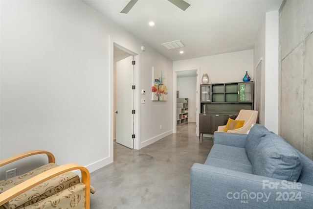 sitting room featuring ceiling fan and concrete floors