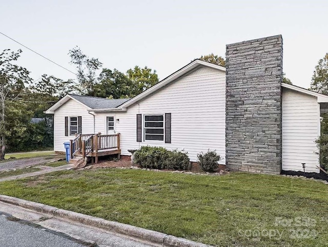 exterior space featuring a wooden deck and a front yard