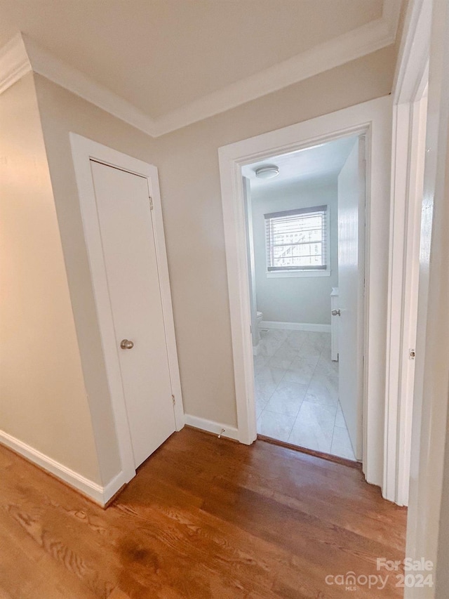 hall with hardwood / wood-style flooring and crown molding