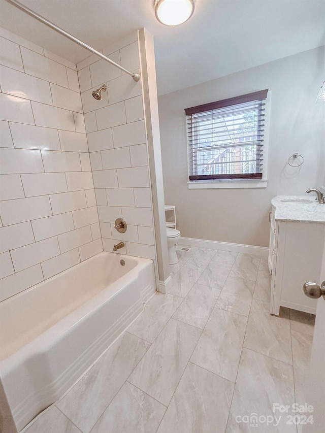 full bathroom featuring tile patterned flooring, vanity, tiled shower / bath combo, and toilet