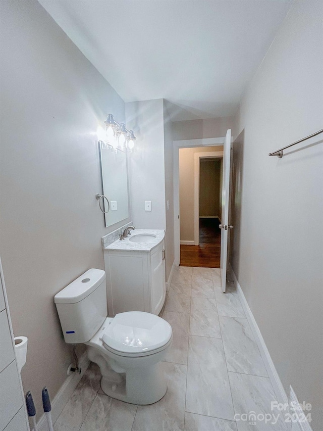 bathroom featuring tile patterned flooring, toilet, and vanity