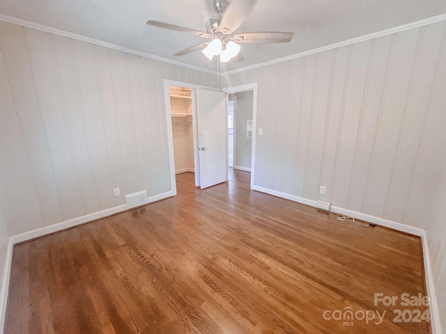 spare room featuring ceiling fan, crown molding, and wood-type flooring