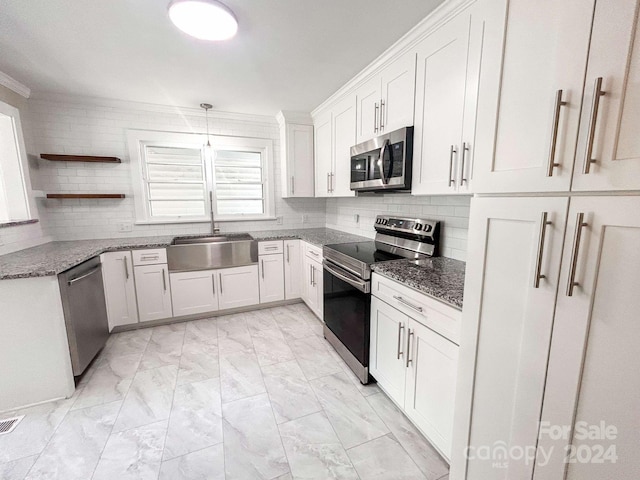 kitchen featuring stainless steel appliances, decorative backsplash, ornamental molding, white cabinetry, and sink