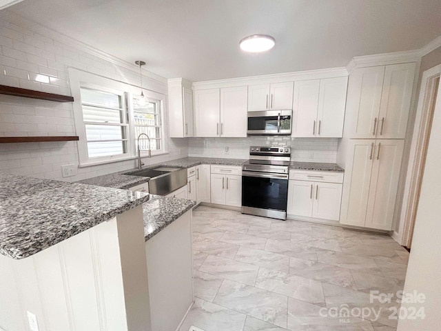 kitchen featuring dark stone counters, white cabinets, light tile patterned floors, sink, and stainless steel appliances