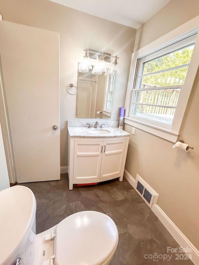 bathroom featuring toilet, vanity, and tile patterned floors