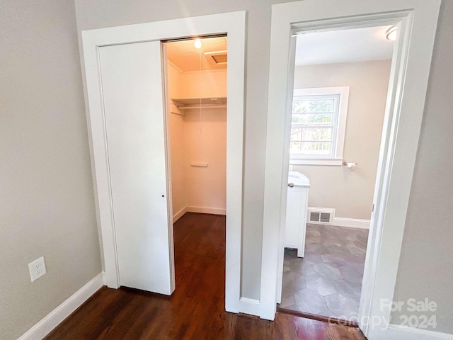 interior space with a spacious closet, a closet, and dark hardwood / wood-style flooring