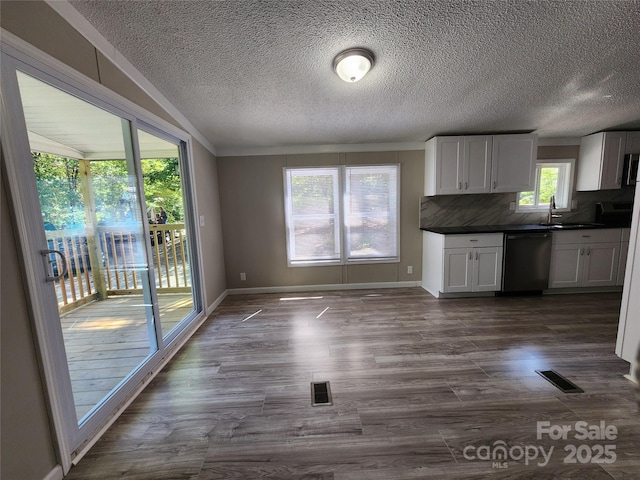 kitchen with sink, white cabinets, backsplash, stainless steel appliances, and dark wood-type flooring