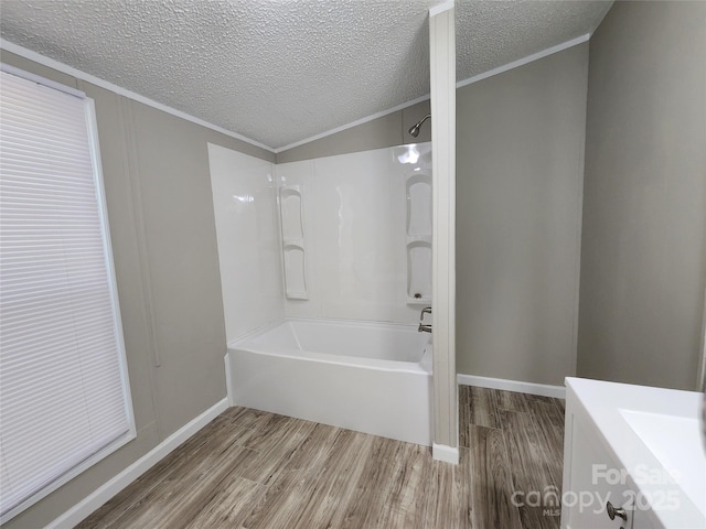 bathroom with shower / bathtub combination, wood-type flooring, a textured ceiling, and ornamental molding