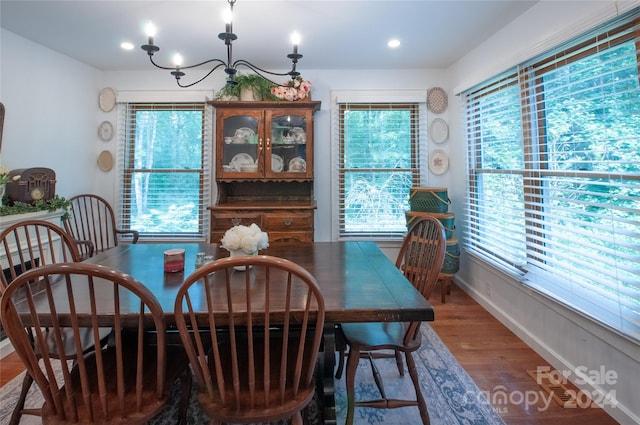 dining room featuring a healthy amount of sunlight, a notable chandelier, and hardwood / wood-style flooring