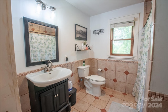 bathroom featuring tile walls, tile patterned flooring, toilet, and vanity