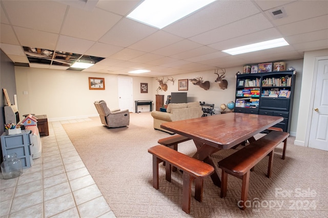 tiled dining space featuring a paneled ceiling