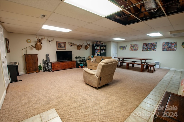 carpeted living room with a drop ceiling