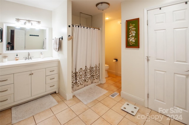 bathroom with vanity, toilet, tile patterned floors, and walk in shower