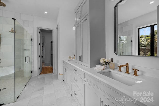 bathroom with a shower with door, vanity, and tile patterned floors