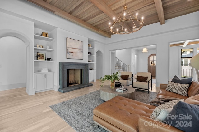 living room featuring a notable chandelier, built in features, light wood-type flooring, beam ceiling, and wooden ceiling