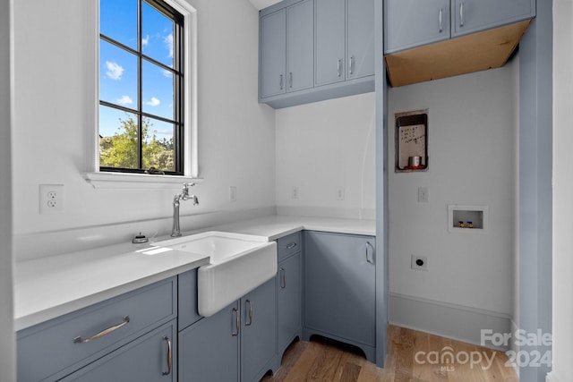 kitchen with sink, gray cabinets, and hardwood / wood-style flooring