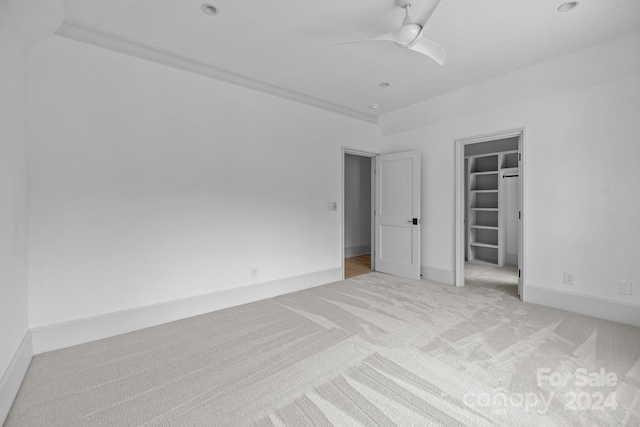 interior space with light colored carpet, built in features, and ceiling fan